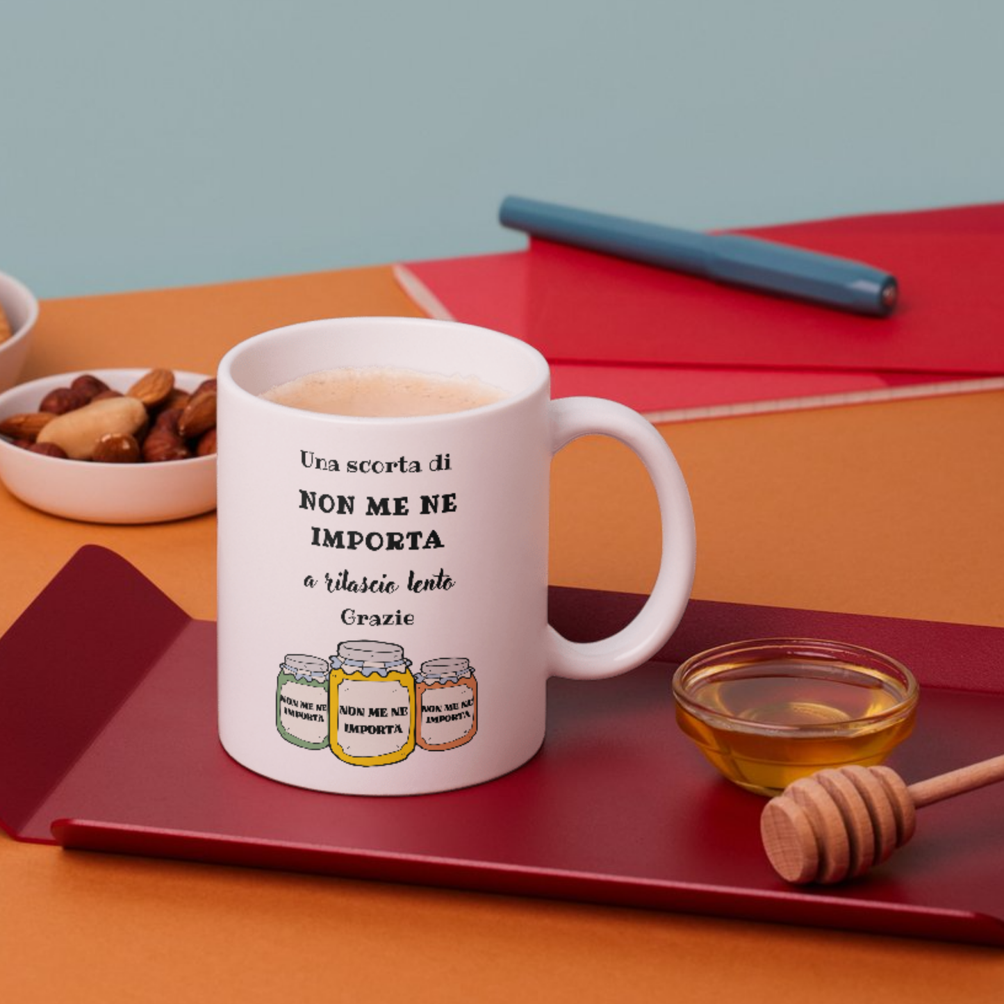 Tazza bianca con scritta "Una scorta di NON ME NE IMPORTA a rilascio lento, Grazie" (fronte), su piano colazione