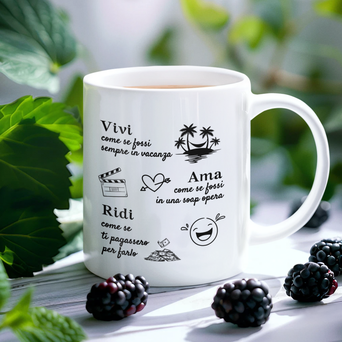 Tazza bianca con scritta "Vivi come se fossi sempre in vacanza, Ama come se fossi in una soap opera, Ridi come se ti pagassero per farlo"  (fronte), su tavolo